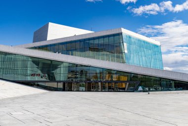 Oslo, Norveç-11 Ağustos 2025: Gökyüzü açık olan Oslo Operası 'nın modern cam cephe ve açısal beyaz mermer çatısına bakınız.