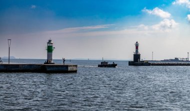 Aarhus, Danimarka-15 Ağustos 2025: Yeşil ve kırmızı çizgili iki küçük liman deniz feneri kılavuz gemileri, deniz ufku ve mavi gökyüzü arkaplanı.