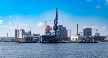 Aarhus, Danimarka-15 Ağustos 2025: Windet kulesi yapım, vinç ve deniz manzaralı Olav de Linde sanayi kompleksi.