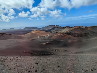 İspanya, Kanarya Adaları, Lanzarote-6 Şubat 2026: Volkanik kraterlerin geniş panoramik manzarası ve mavi gökyüzü altında akan lav alanları.