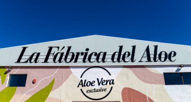 İspanya, Kanarya Adaları, Fuerteventura-5 Şubat 2026: Fuerteventura 'da açık mavi gökyüzü altında Aloe Vera özel logosuyla La Fabrica del Aloe binasının cephesi.