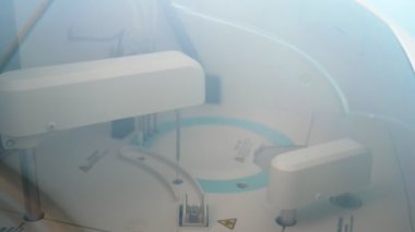 Çağdaş kan testi cihazı çalışıyor ve kan örneklerini kontrol ediyor. İçinde uzun iğneler bulunan modern bir plastik kan testi cihazının yakın çekimine çarpıyor. Terbiyesiz, hoş ve güvenilir görünüyor..