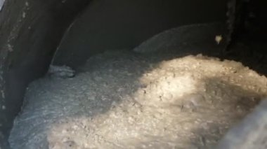 Beton karıştırıcı, çimento, kum ve suyla dönüyor. İnşaat alanı için yüksek kaliteli beton karışımı yapmak için çimento, kum ve suyu çimentoyla karıştırıp, çimentoyla karıştırıp, çimentoyu birbirine karıştırıyor.