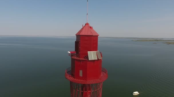 夏の美しい海とセレステの空を望む赤い灯台の空中撮影夏の晴れた日に水平線のない黒海とセレステの空にそびえる赤い灯台の印象的な鳥の目の景色 それは刺激的で夢のように見える — ストック動画
