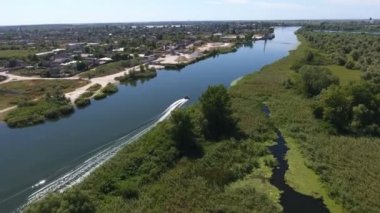 Yaz mevsiminde Dnipro Havzası 'nda yüzen motorlu bir teknenin havadan çekilmiş görüntüleri. Muhteşem bir kuş bakışı. Yazın güneşli bir günde, Dnipro Havzası' nda, insanlarla birlikte düz bir kanal boyunca yüzen güçlü bir motorlu tekne..
