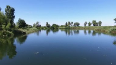 Yazın Dinyeper bölgesinde ışıl ışıl yüzeyi olan pitoresk bir körfezin havadan çekilmiş görüntüsü. Güneşli bir yaz gününde, Dnipro bölgesinde, yüzeye bakan düz bir kanala ve kabarık ağaçlara bakan şaşırtıcı bir kuş bakışı..