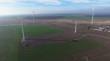 Yazın dönen bıçaklarla dolu yüksek rüzgar enerjili sütunların havadan çekilmiş görüntüsü güneşli bir yaz gününde deniz kenarında rüzgar enerjisi toplayan yüksek beyaz sütunların çizgili kuşbakışı görüntüsü.. 