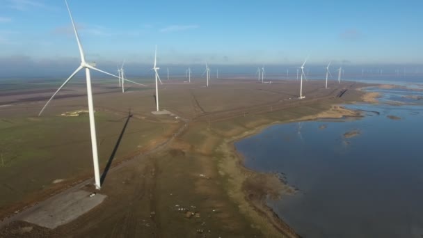 Повітряний Знімок Ліній Вітроенергетичних Полюсів Нерухомими Лопатями Узбережжі Чудовий Вид — стокове відео