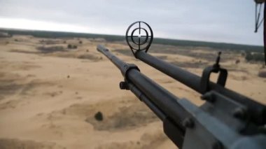 Kartuş bantlı hava makineli tüfeği, 12.7 mm 'lik bir makineli tüfeğin ve bahar havasında uçan helikopterlere yerleştirilmiş çöl nesnelerini hedef alan yuvarlak görüş açısına sahip 12.7 mm' lik bir helikopterden çöl nesnelerine nişan alır..