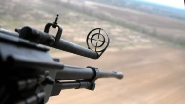 12.7 mm 'lik ön görüşlü makineli tüfek, 12.7 mm' lik bir makineli tüfekle 12.7 mm 'lik bir makineli tüfeği ve baharda bulutlu bir havada helikopterle uçmayı hedefleyen orman şeridini hedefliyor.
