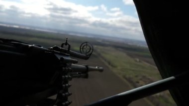 Kartuş bantlı modern makineli tüfekler, hava şartlarında uçan helikopterlere sabitlenmiş kara cisimlerini hedef alan, modern bir makineli tüfeğin kartuş bandı ve yuvarlak bir ön görüşü olan helikopter objelerini hedef alır..