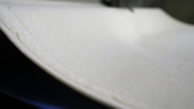 Modern bir fırın fabrikasında geniş bir hamur katmanı, geniş bir konveyör bandına biniyor. Lezzetli kruvasanlar için harika bir hamur tabakası, güncel bir fırın fabrikasında geniş bir taşıyıcı bant üzerinde ilerliyor. Profesyonel ve ilham verici görünüyor..