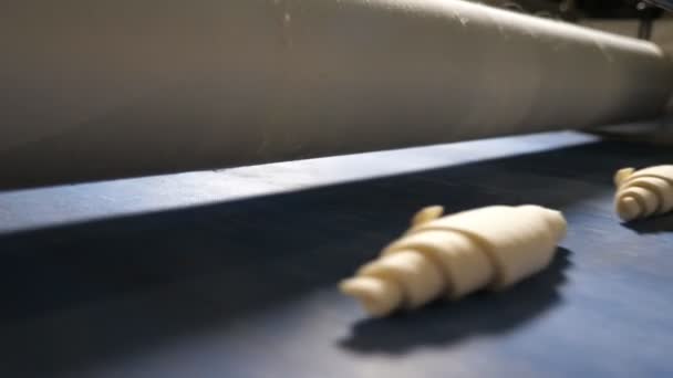 在一家面包店的橱窗里 看到一条宽宽的传送带 上面有几行面团面包 在一个现代面包店的沉重滑梯下自动移动 很乐观 — 图库视频影像