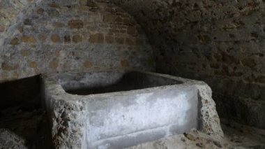 Ukrayna 'nın Murky Ortaçağ taş dondurucusundaki kırmızı tuğlalardan yapılmış eski bir bodrumda kırmızı tuğlalardan yapılmış ve Ukrayna' daki bir küvete benzeyen sert öğütücü taş dondurucu. Eski, lekelenmiş ve kırsal görünüyor..