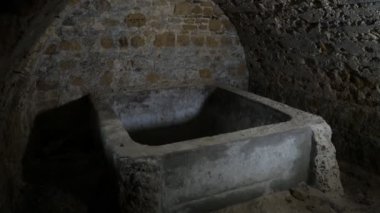 Ukrayna 'daki kırmızı tuğlalardan yapılmış eski bir bodrumda orta yaşlı taş dondurucu. Kırmızı tuğlalardan yapılmış eski bir kilerde ve Ukrayna' daki küvete benziyor. Alışılmadık, karanlık ve kasvetli görünüyor.