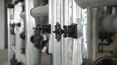Modern bir soya yağı fabrikasındaki dar borulara birkaç küçük yuvarlak musluk. Çağdaş bir soya fasulyesi üretim tesisinin dar ve kısa borularına yapılmış iki küçük musluk. Neşeli ve güzel görünüyor..
