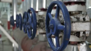 Bir sıra büyük yuvarlak musluk, soya fasulyesi yağı fabrikasındaki büyük bir boruya çarpıyor. Doğu Avrupa 'daki modern soya fasulyesi üretim tesisinin içinde büyük ve geniş bir boru hattı üzerine. Orijinal ve iyi görünüyor..