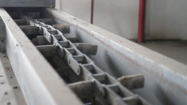 Soya fasulyesi üretim tesisinde yatay hareket eden boş metalik taşıyıcı. Soya fasulyesi üretim tesisinde yatay çalışan bir zincir ile çalışan boş bir metalik taşıyıcının profesyonel görüntüsü. Güzel ve neşeli görünüyor..