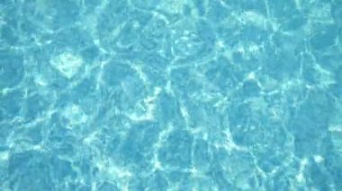 Yazın güneşli bir günde, güneşli bir günde, güneşli bir havuzda güneşli bir havuzda güneşli bir havuzda güneş ışınları eşliğinde şeffaf turkuaz su manzaralı kristal bir su. Muhteşem, iyimser ve iyi görünüyor..