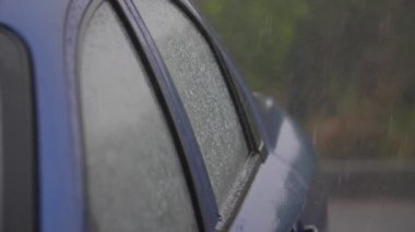 Sonbaharda şiddetli yağmur altında modern araba penceresi damlayan damlalar yoğun duş altında çağdaş bir otomobil penceresinin etkileyici görüntüsü ve sonbaharda sisli ve yağmurlu havada damlacıklar aşağı iniyor. Melankoliye ilham verir..