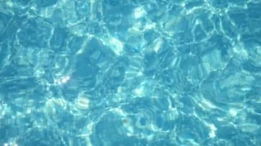 Köpüklü sular mavi bir yüzme havuzunda kaleydoskopik bir şekilde oynayarak örümcek ağını şekillendiriyor açık mavi dalgaların modern bir yüzme havuzunda yavaşça sallanışını, rahatlatıcı desenleri ve güneş ışınlarından örümcek ağı oluşturan izleri. Sihirli görünüyor..