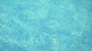 Açık mavi su, güzel bir yüzme havuzunda kaleydosik olarak hareket eder. Turkuaz dalgaların modern bir yüzme havuzunda yavaşça ve etkileyici bir şekilde hareket ederek rahatlatıcı desenler ve izler oluşturmasını sağlar. Harika görünüyor..