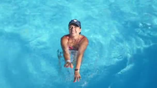 Jolly Γυναίκα Χαμογελά Και Κολυμπά Στο Χείλος Της Πισίνας Μπλε — Αρχείο Βίντεο