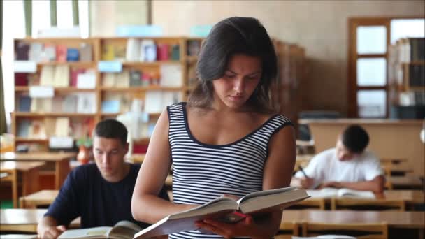 A könyvtár néz a kamerába, és mosolyog a 3 fiatal lány — Stock videók