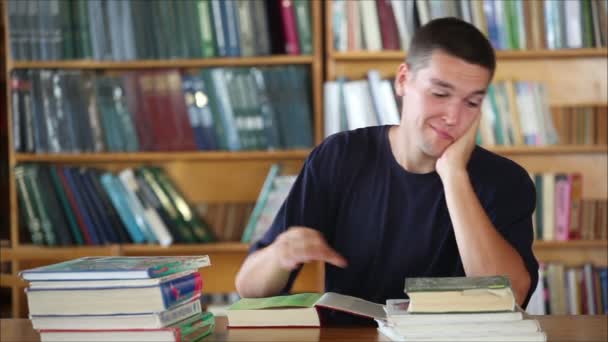 Estudiante cansado en la biblioteca leyendo libros 3 — Vídeo de stock