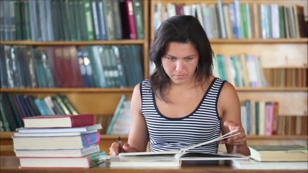 Mooi meisje student in de bibliotheek — Stockvideo