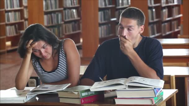 Втомлені студенти в бібліотеці читають книги 1 — стокове відео