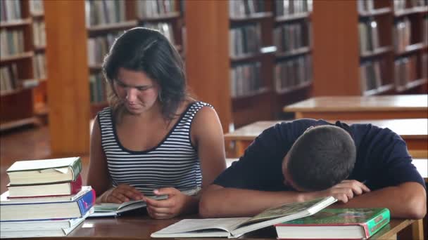 Estudiantes cansados en la biblioteca leyendo libros 3 — Vídeo de stock