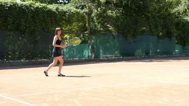 Mujer juega al tenis en el entrenamiento de cámara lenta — Vídeos de Stock