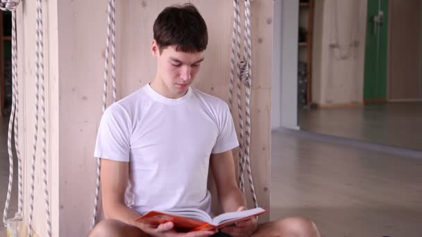 Chico guapo leyendo un libro — Vídeo de stock