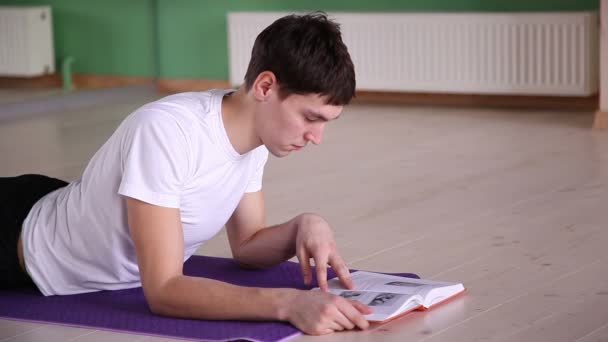 Knappe jongen lezen van een boek 2 — Stockvideo