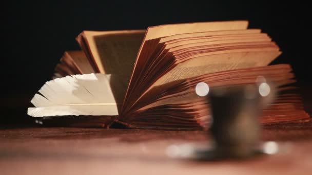 Старая книга и чашка на столе — стоковое видео