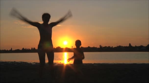 Gelukkige familie spelen op strand — Stockvideo