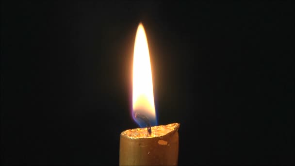 Свічка, що горить на чорному тлі — стокове відео