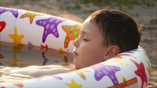 Chłopiec leżące w basenie — Wideo stockowe