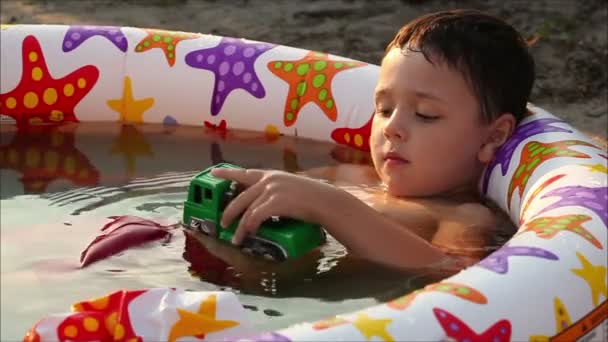 Niño acostado en la piscina — Vídeos de Stock