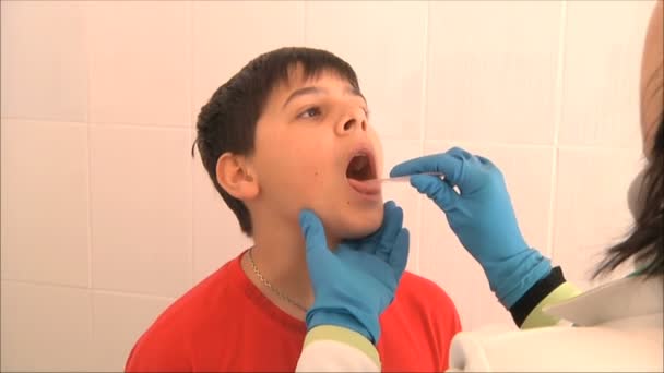 Doctor examines the boy his throat — Stock Video