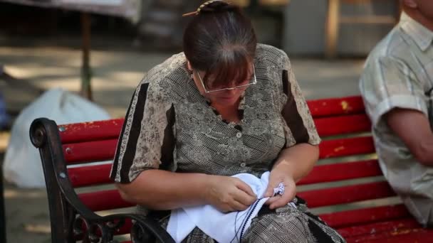 Woman embroider on street — Stock Video