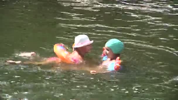 Los niños flotan en el río — Vídeos de Stock