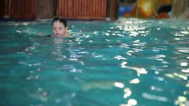 Küçük bir çocuk havuzda oynarken — Stok video