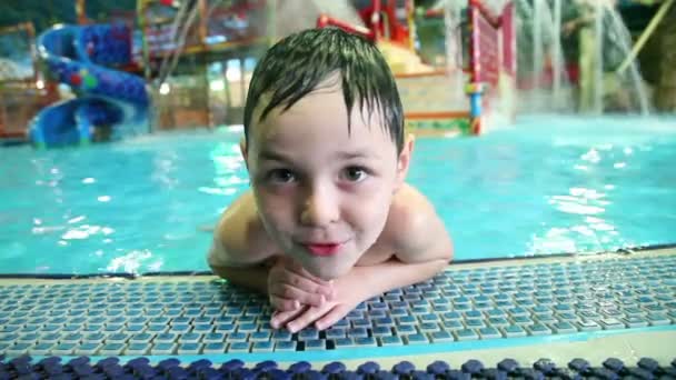 Маленький мальчик играет в бассейне — стоковое видео