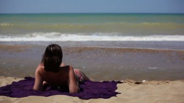 Kumsalda oturan kadın.