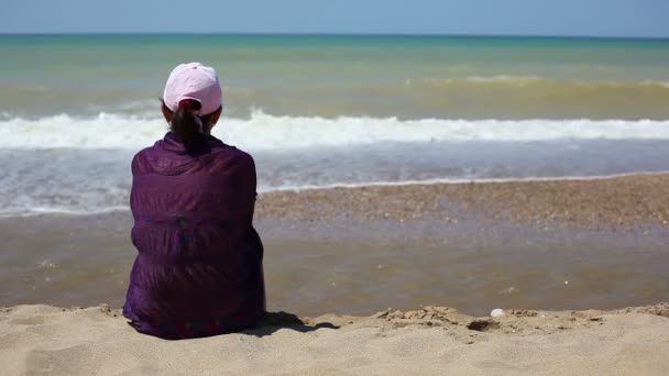 Mujer sentada en la playa — Vídeos de Stock