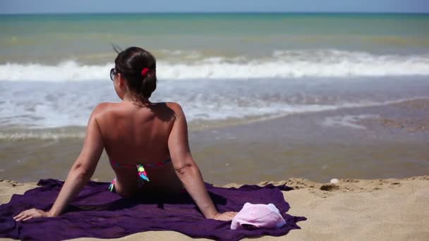 Vrouw zittend op het strand — Stockvideo