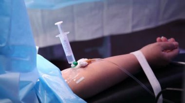 Elinde tıbbi iğne var.