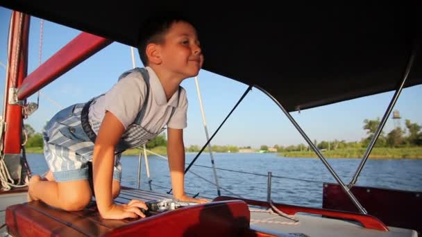Усміхаючись хлопчик на яхті — стокове відео